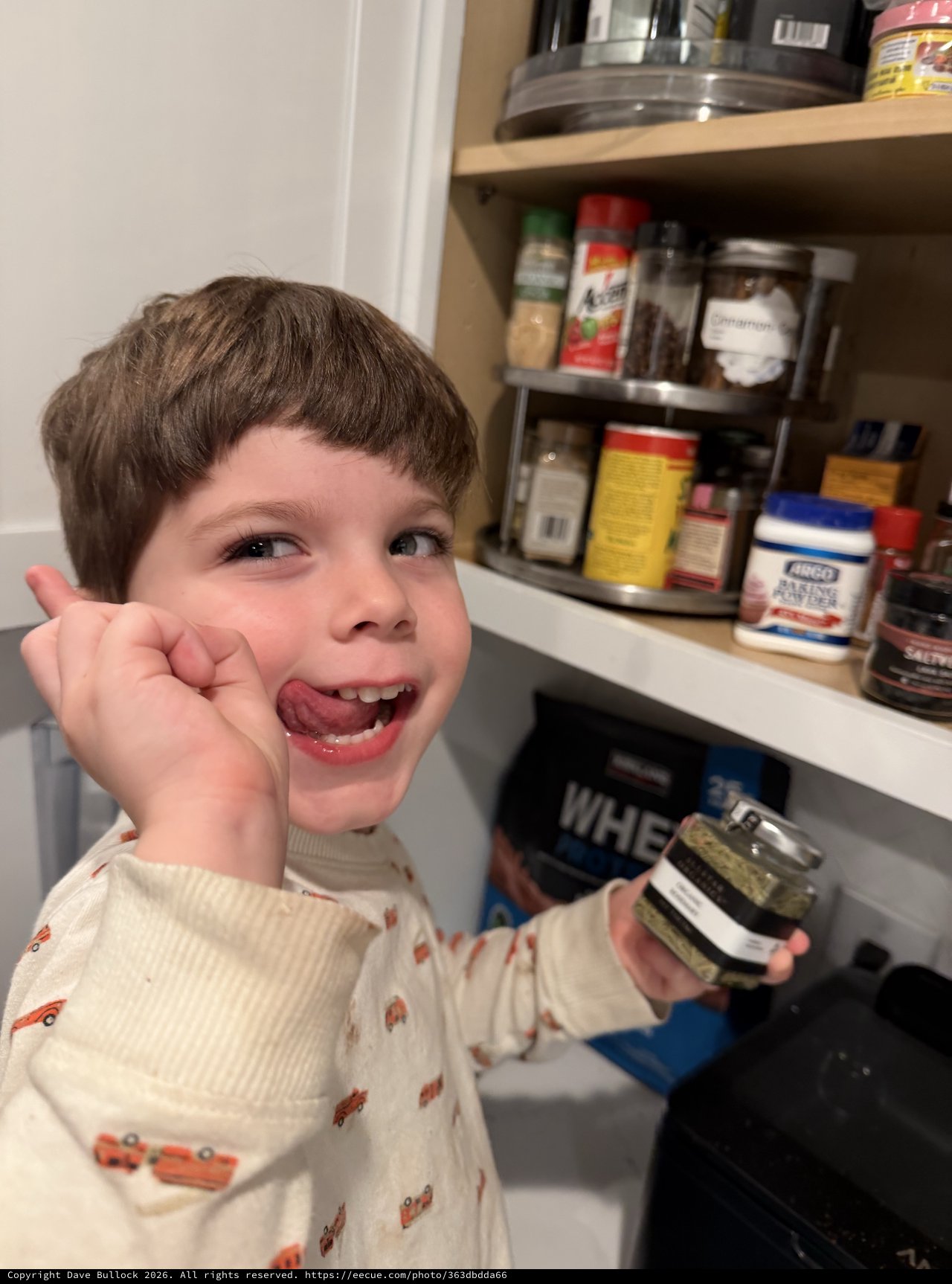 Young Boy Enjoys Snack Time in Kitchen Pantry