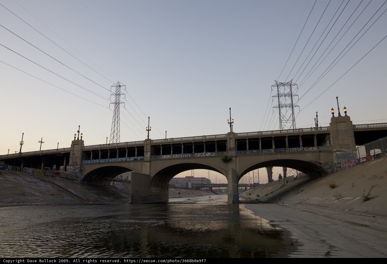 Rushing Waters Beneath the Freeway Overpass