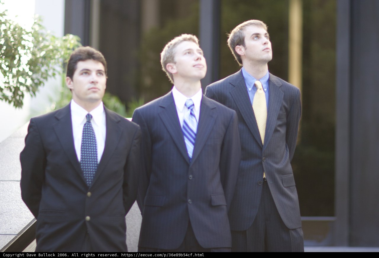 Three Men in Suits Posed in Front of a Building