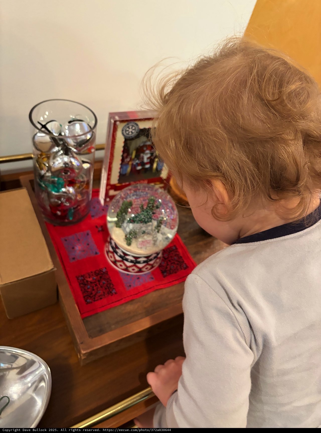 Young Child Discovering Christmas Snow Globe Wonders