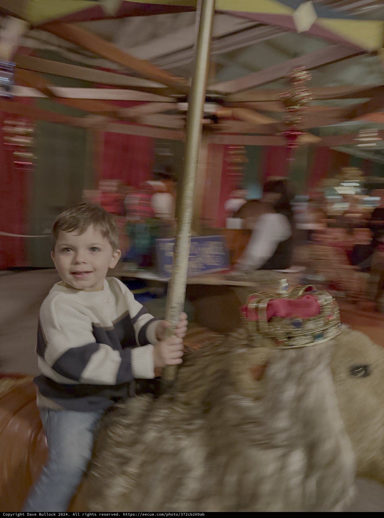 Child Enjoying Carousel Ride at Amusement Park