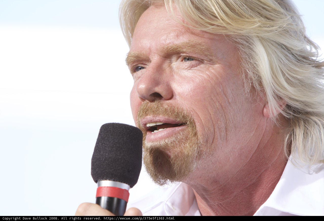 Richard Branson Addressing the Crowd with Microphone in Hand
