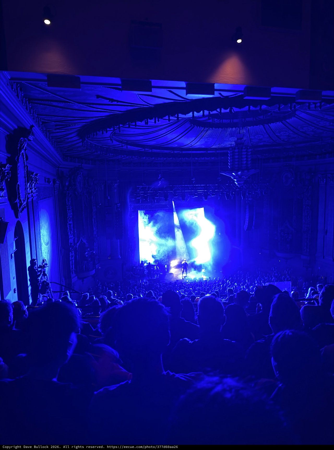 Concert Performance in Historic Ornate Theater with Blue Stage Lighting