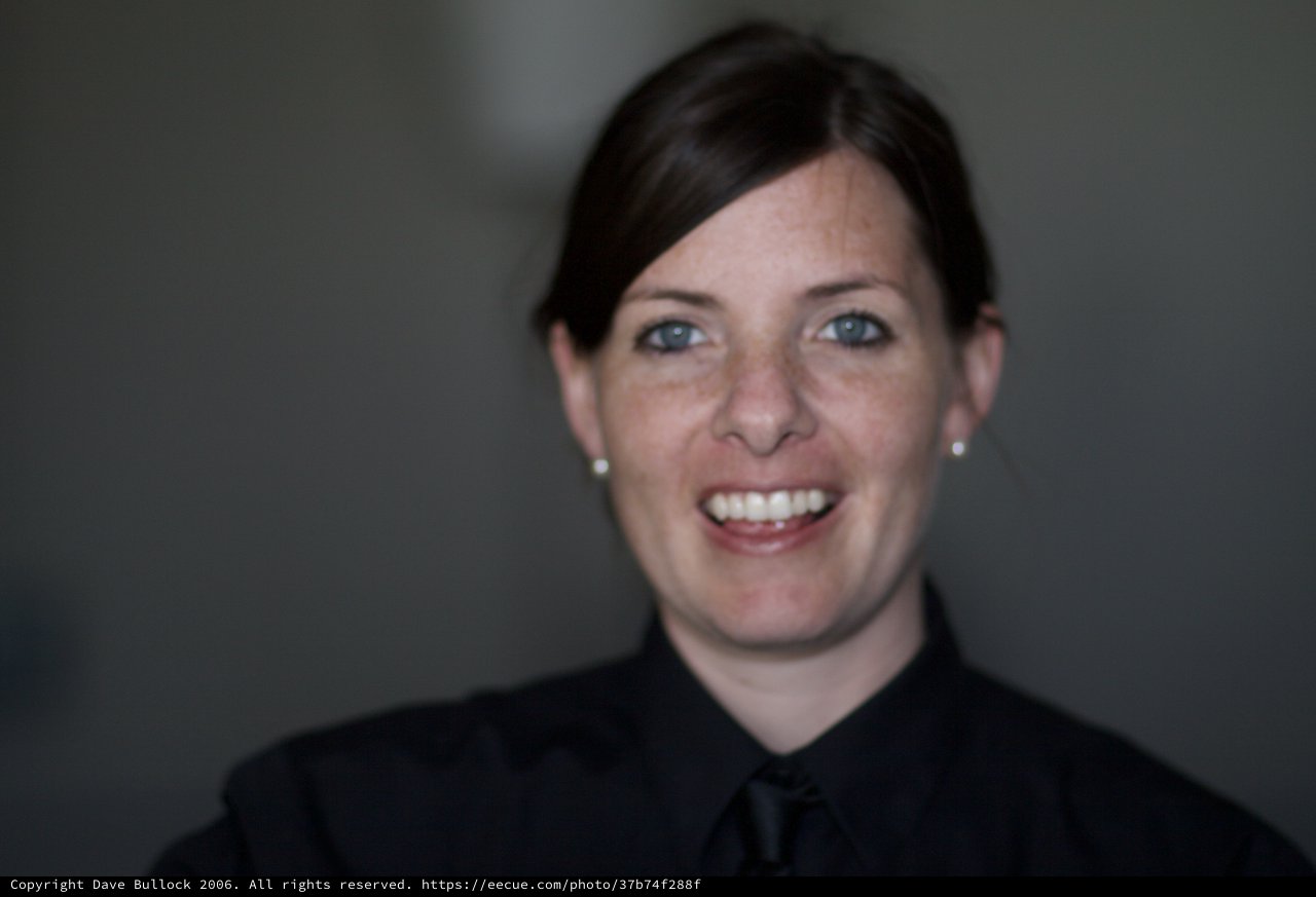 Smiling Woman in Black Against Grey Background