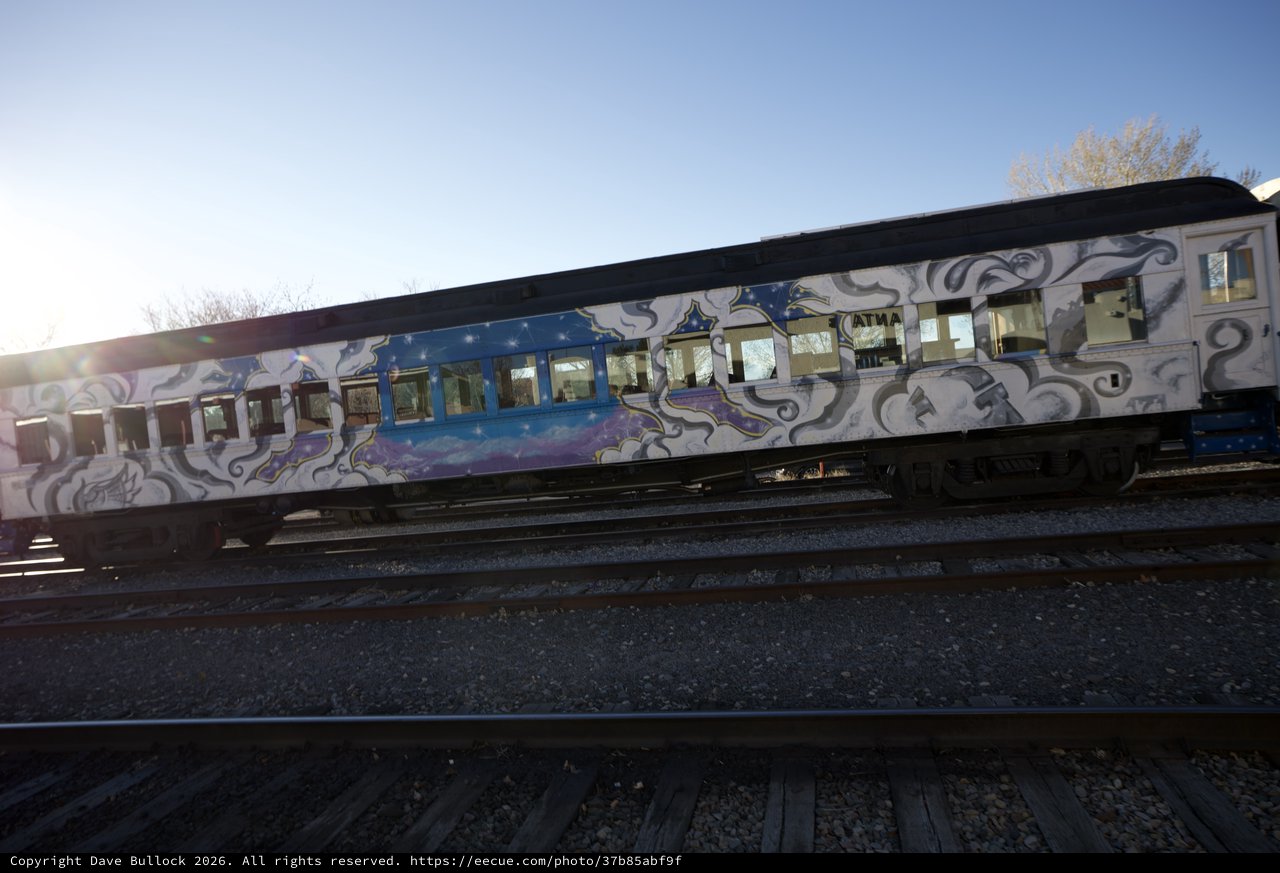 Graffiti-Adorned Train Cars on Railroad Tracks at Sunset