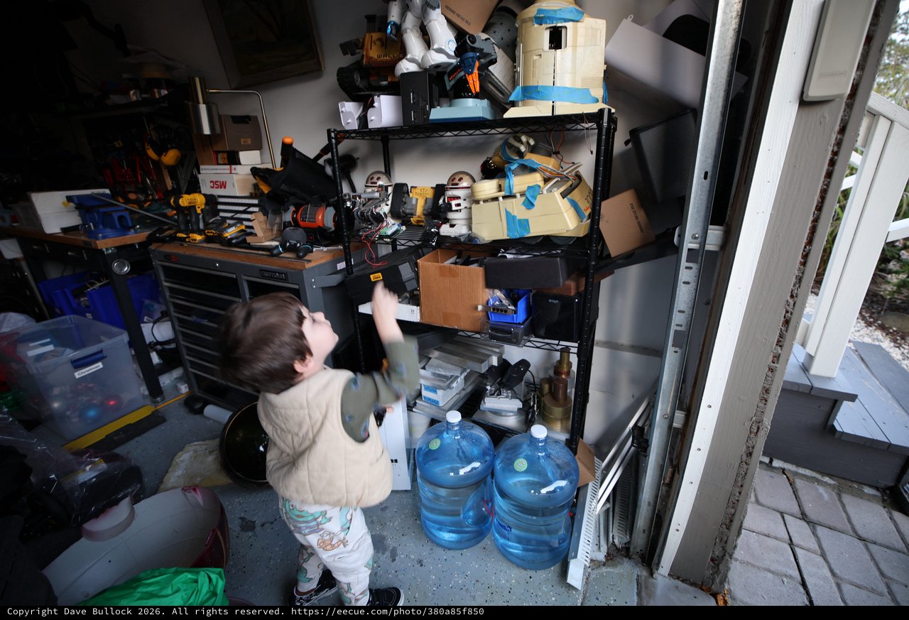 Toddler Exploring Cluttered Garage Workshop Storage