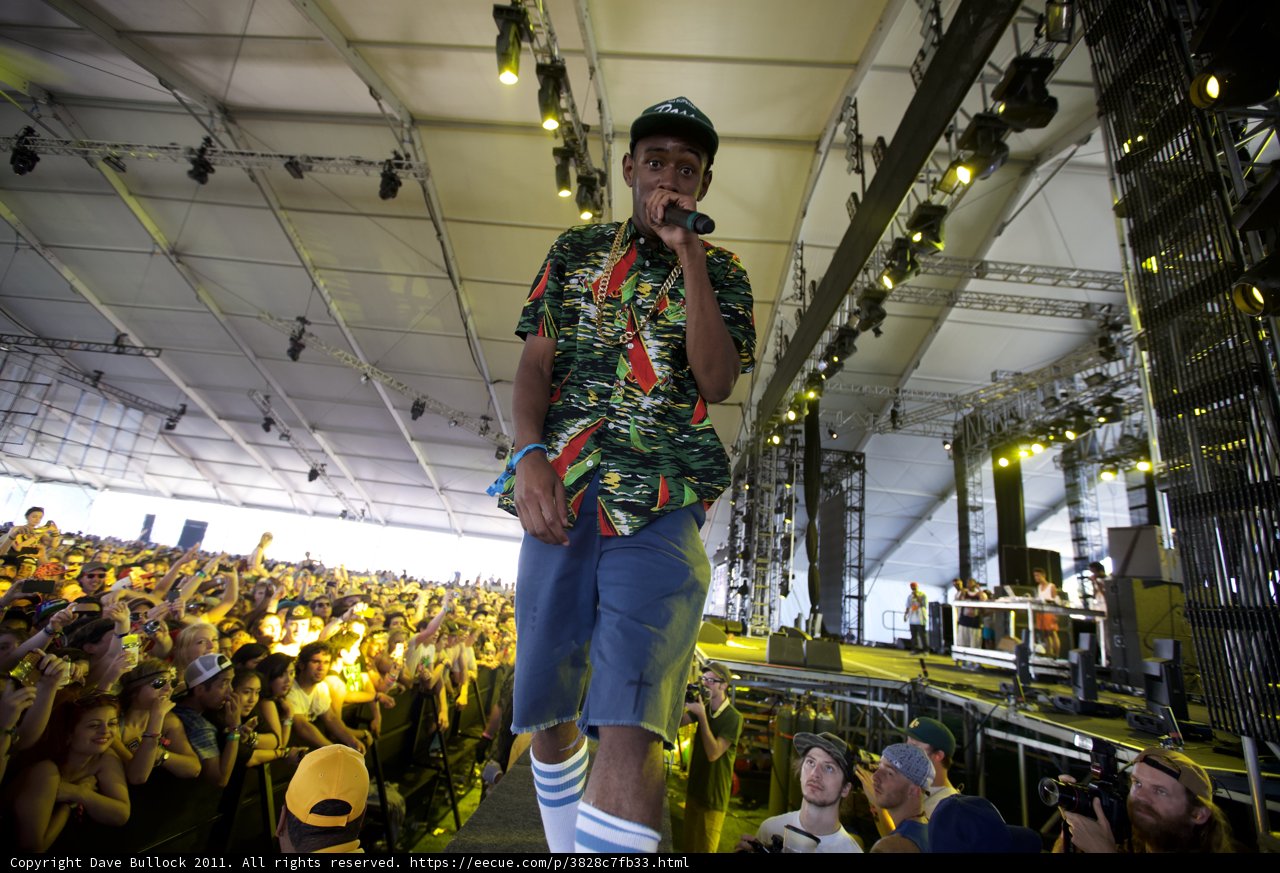 Man on Stage in Tropical Clothes Caption: Tyler, The Creator performs in a colorful shirt and shorts for a crowd of fans at Coachella 2011 on Friday.