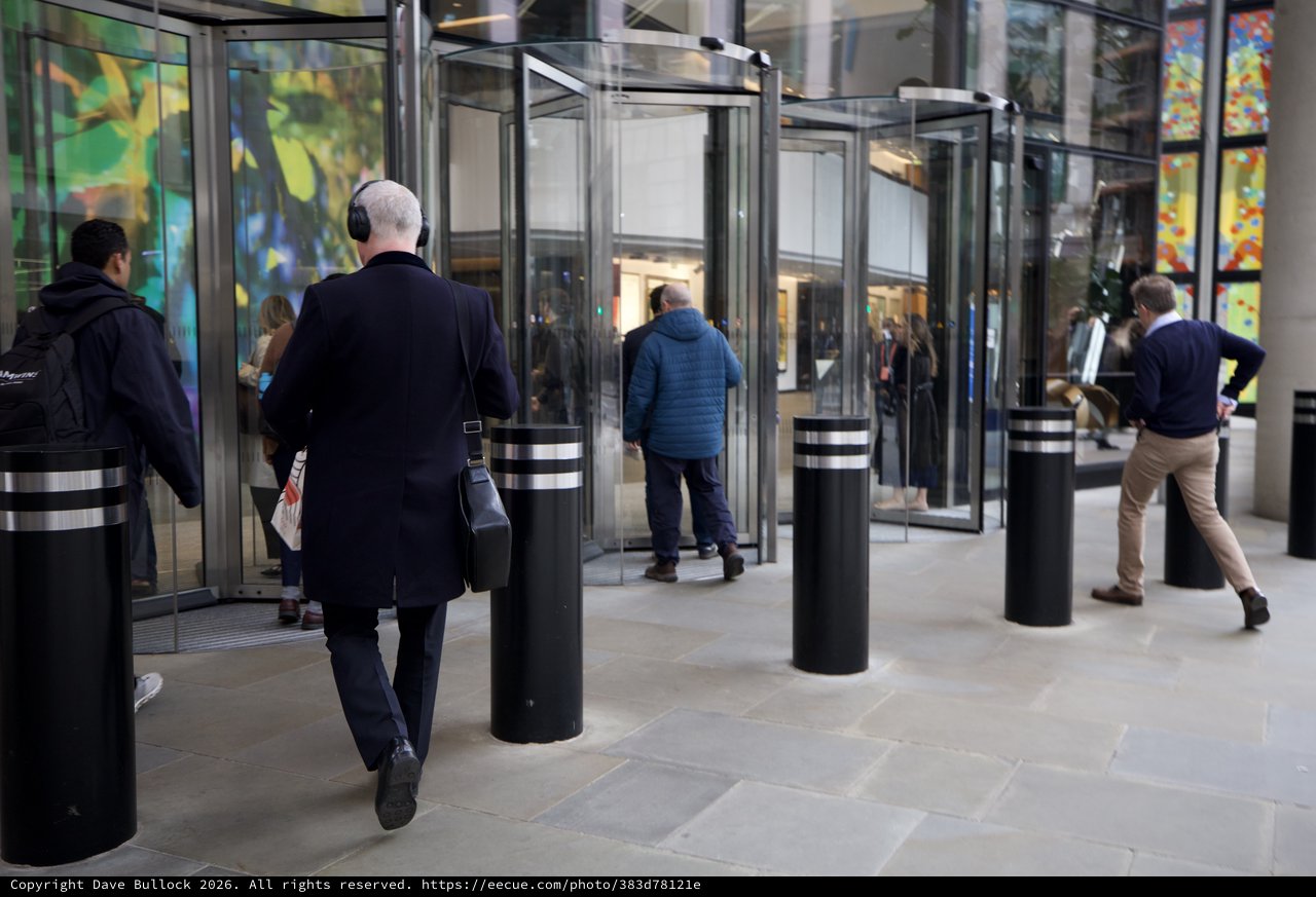 Urban Professionals Navigate Modern Glass Revolving Doors