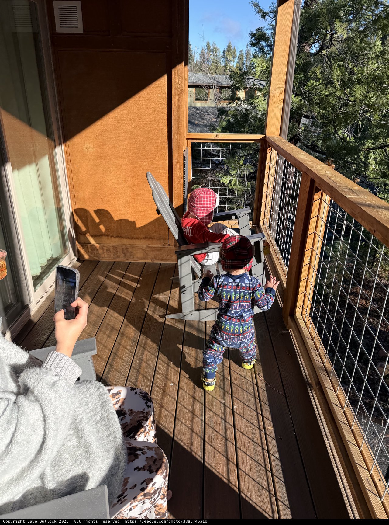 Toddlers Exploring Snowy Mountain Cabin Deck Together