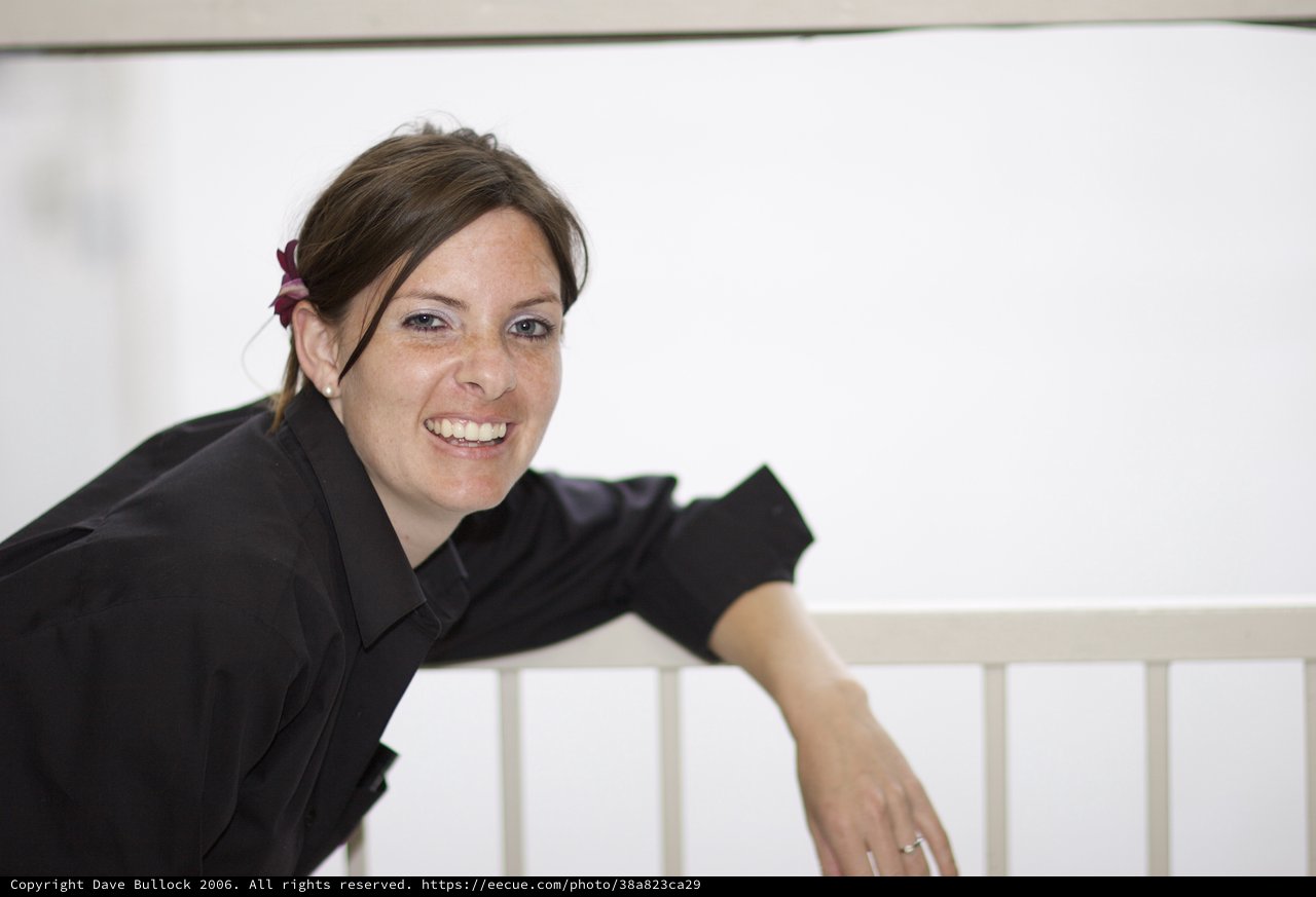 Smiling Woman Leaning on White Railing Portrait