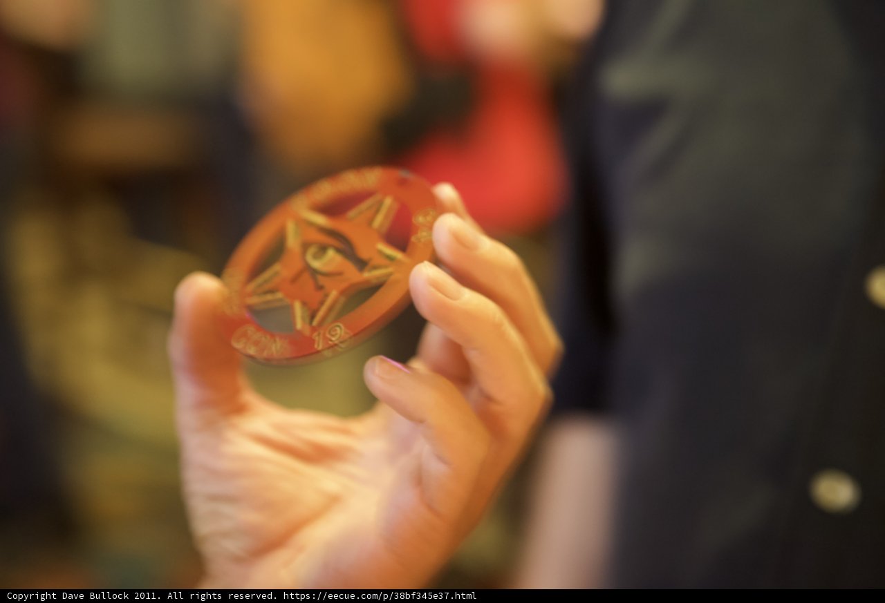 Star-Studded Coin Held by Two Fingers