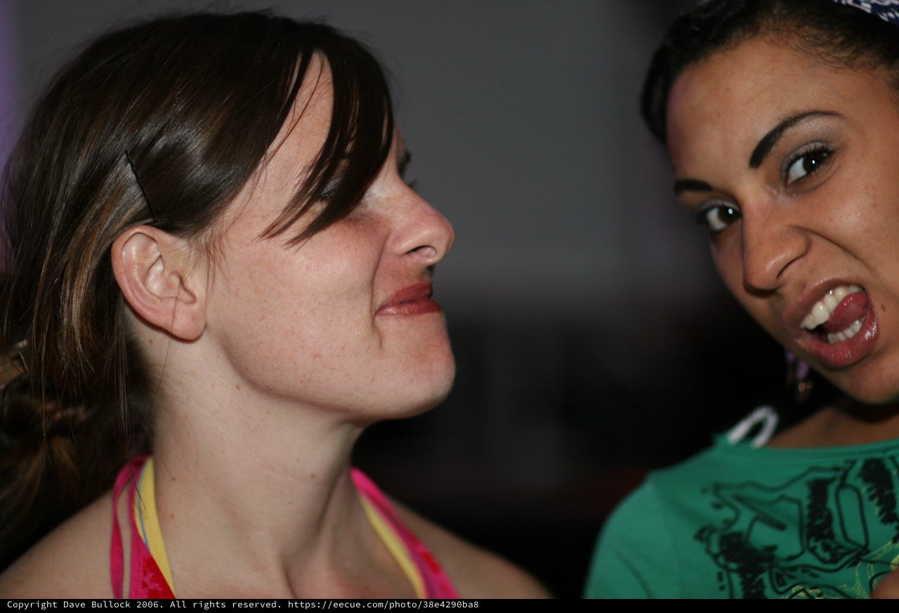 Two Women Share a Playful Moment at Night Event