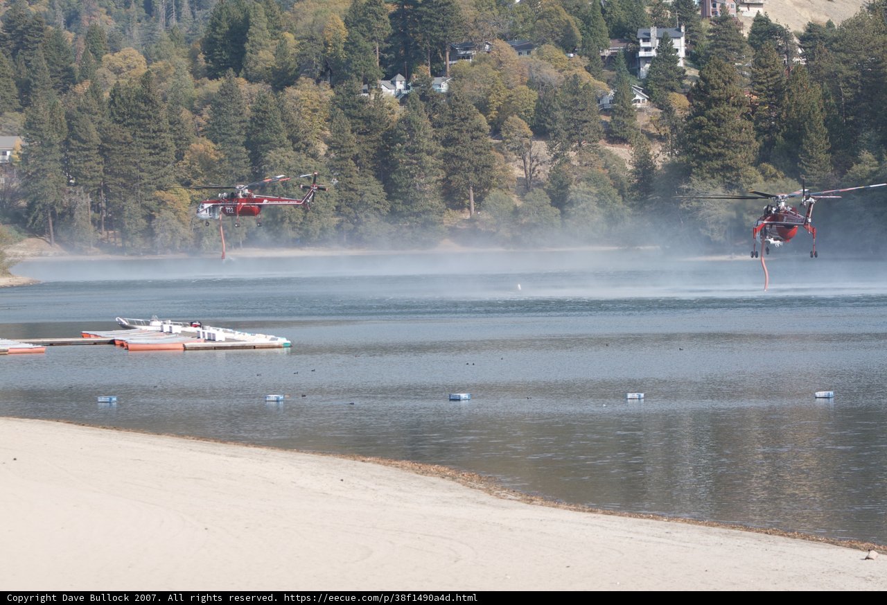 Two Helicopters Fly Over Lake with Boat