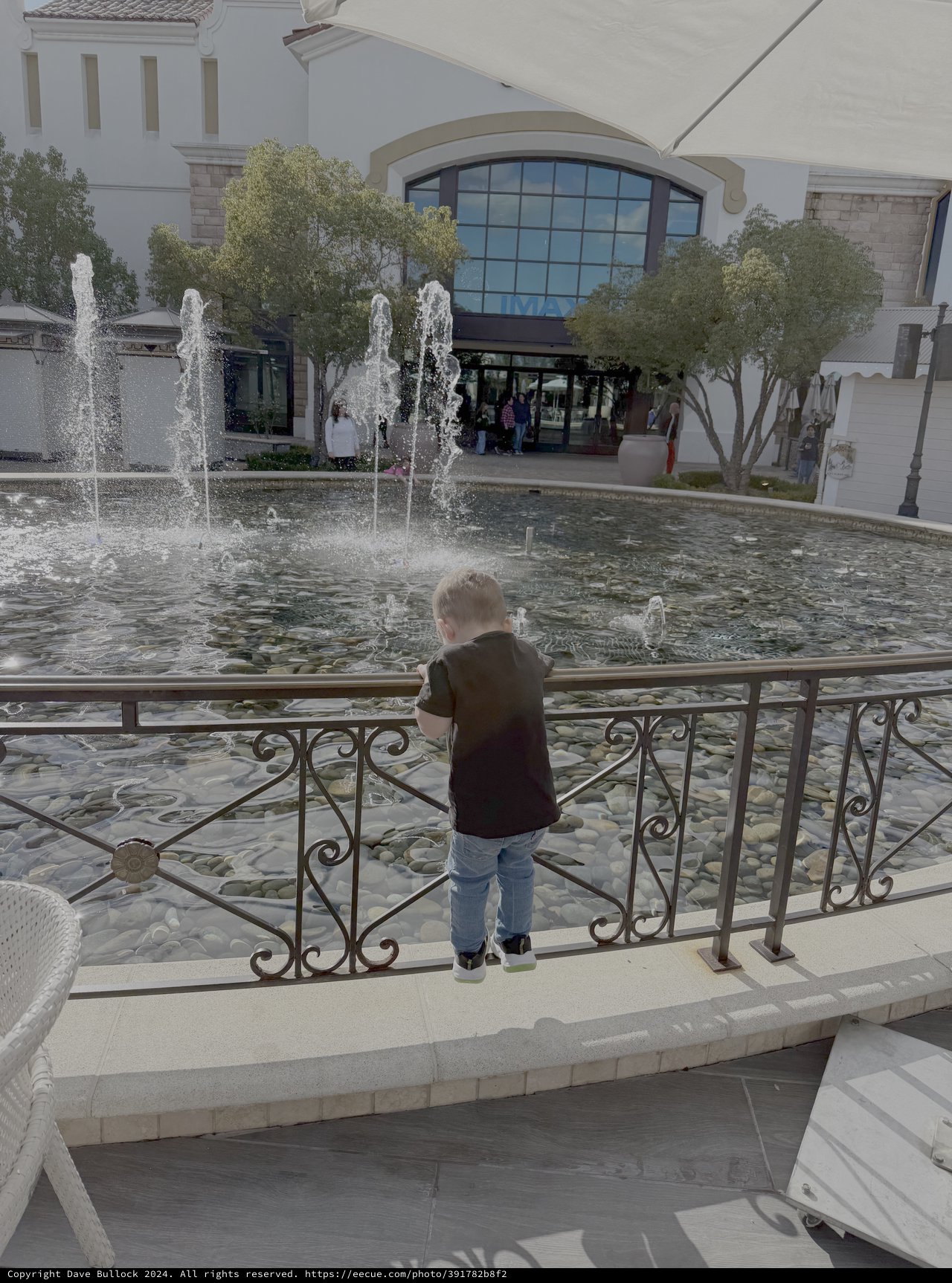 Child Watching Fountain at Elegant Shopping Center