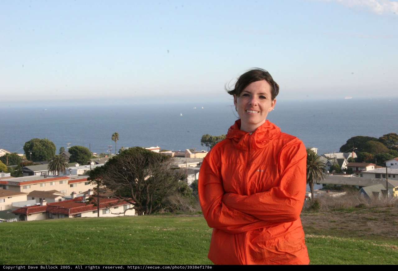 Woman in Orange Jacket Overlooking Coastal California Town