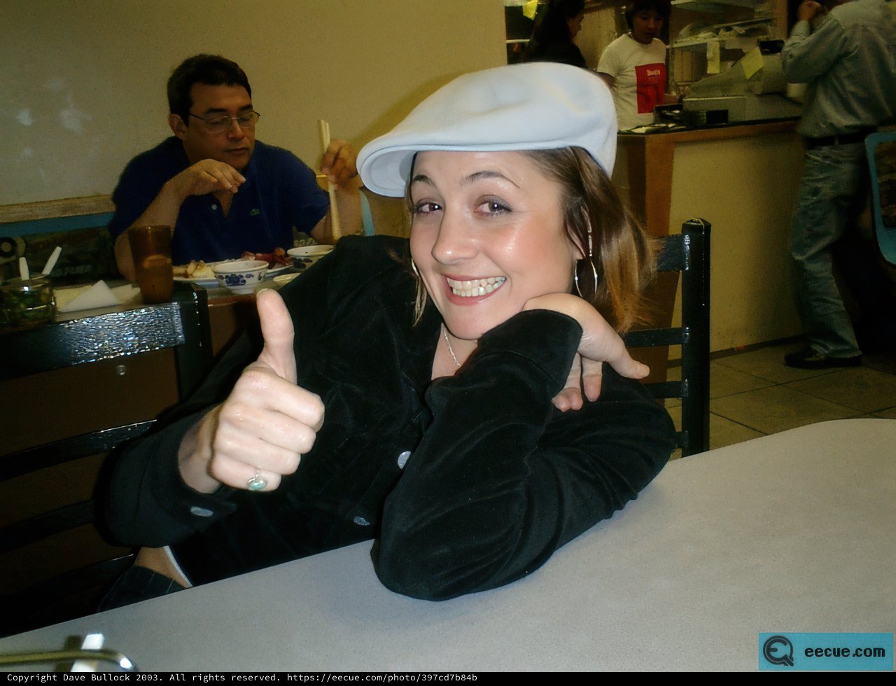 Stylish Woman in Hat Enjoying a Meal with Friends
