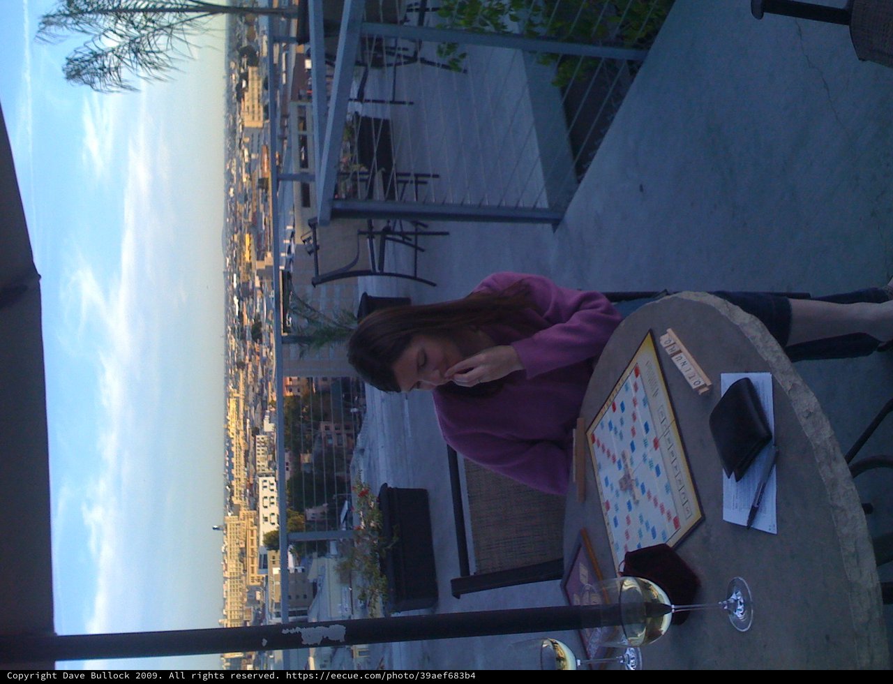 Rooftop Scrabble Game at Dusk Over City Skyline