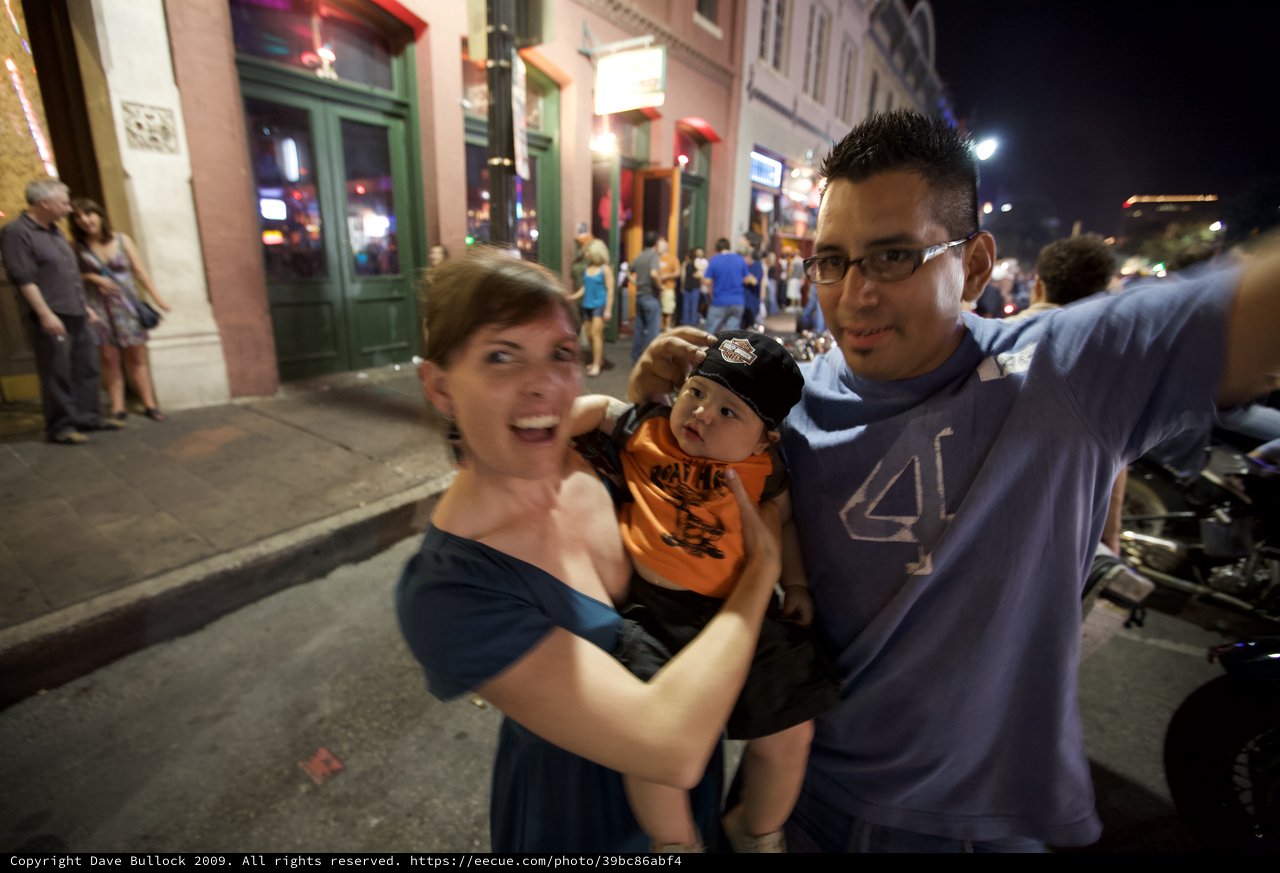 Young Family Celebrates on Austin Street at Night