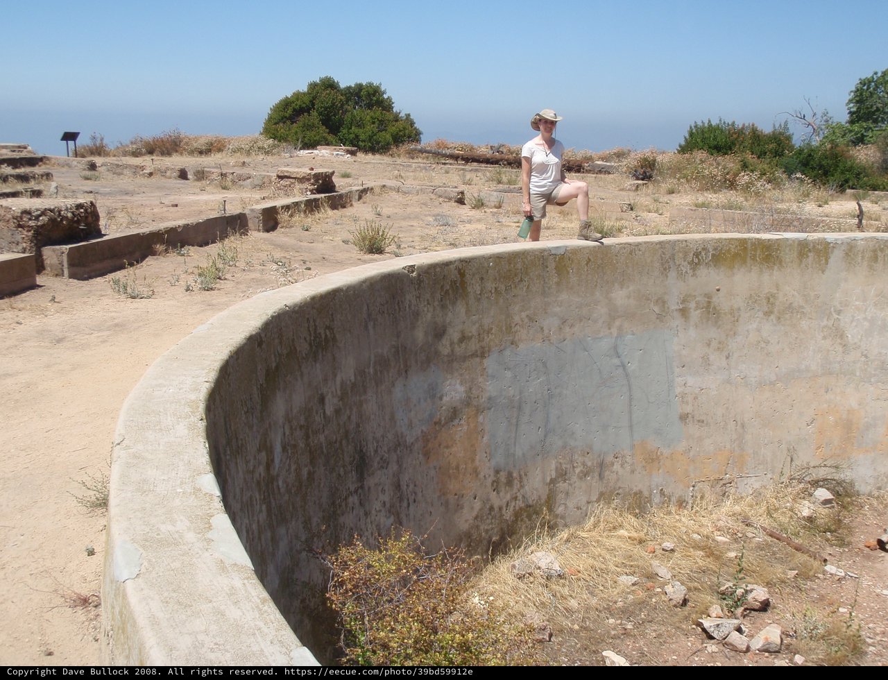 Explorer Poses on Abandoned Concrete Gun Emplacement Ruins