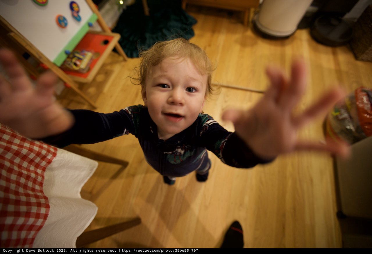 Toddler Reaching Up with Joy on Christmas Morning