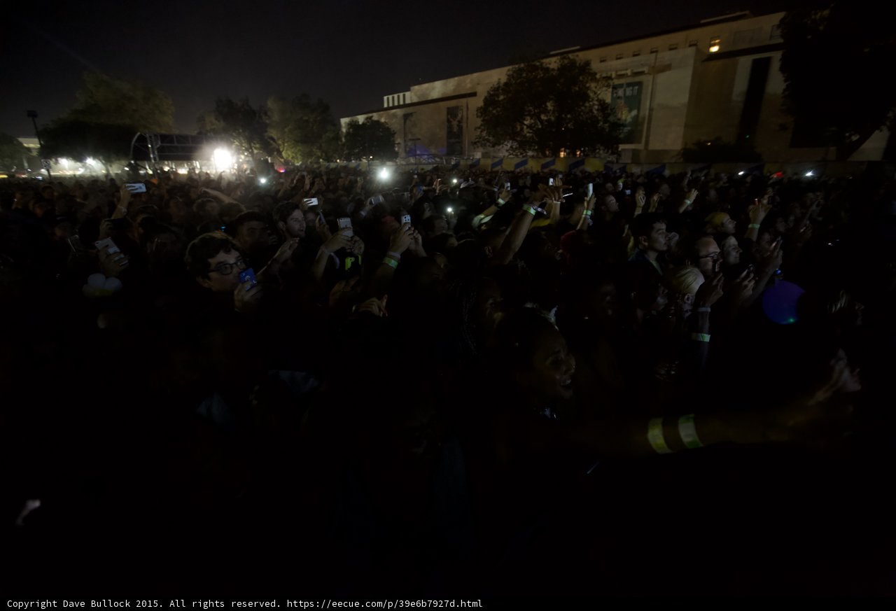 FYF Fest Festival Crowd Night Phones Raised Stage Scaffolding Trees Building Wristband Arm
