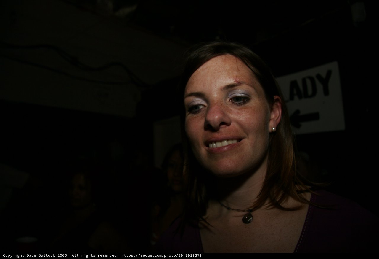 Woman Smiling in Dimly Lit Nightlife Venue