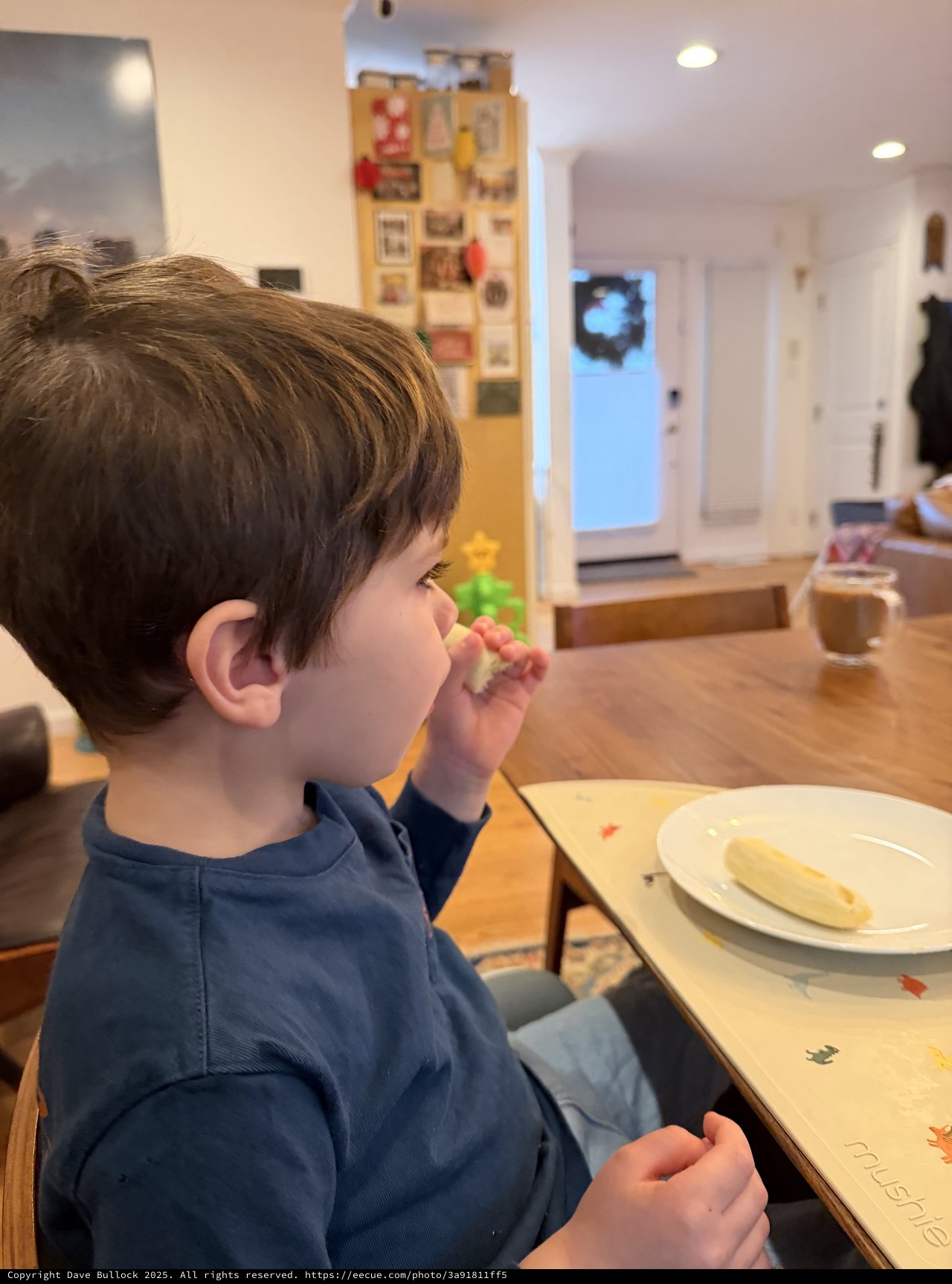 Young Child Enjoying Snack Time at Kitchen Table