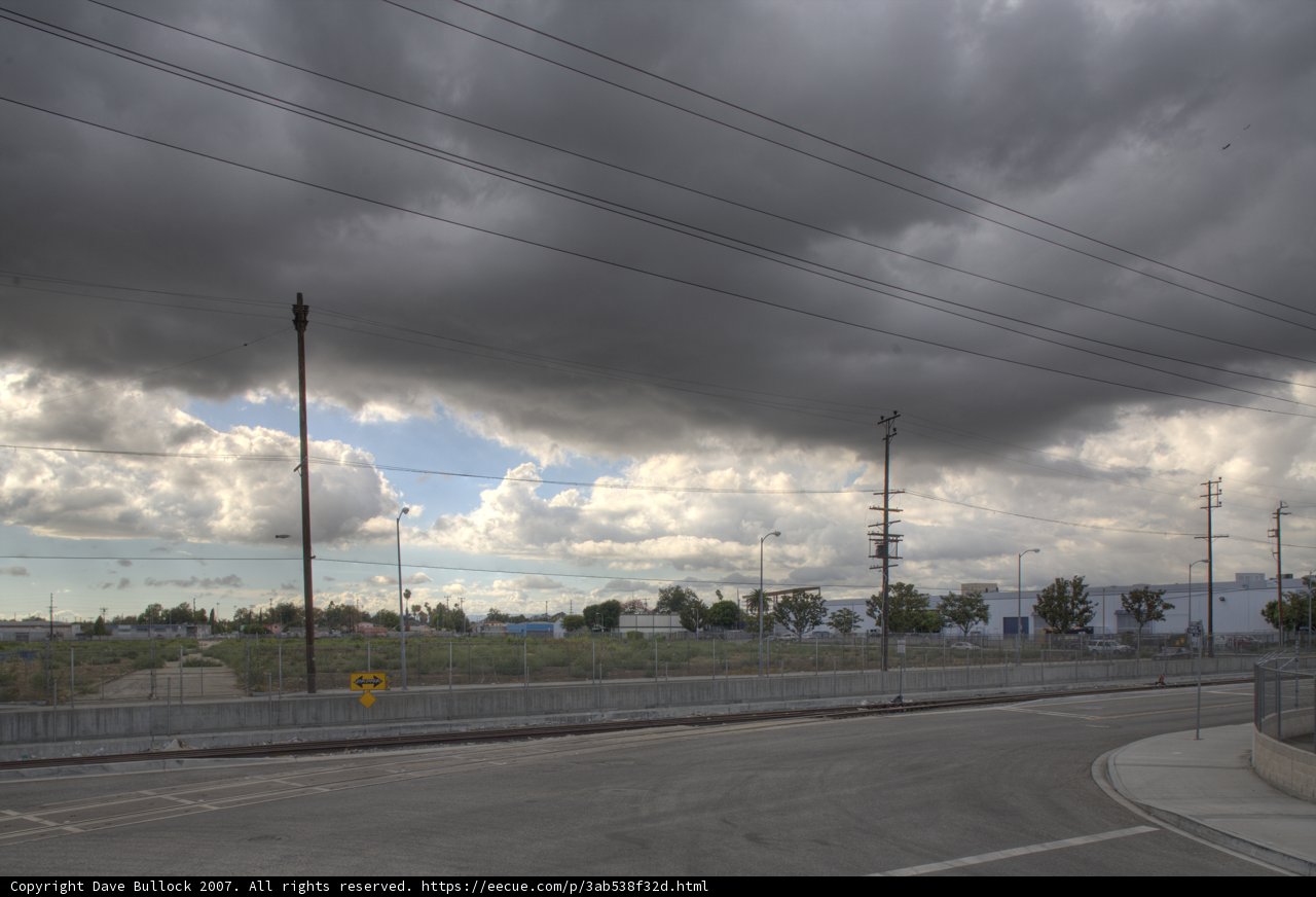 Cloudy Sky Over a Road with Power Lines