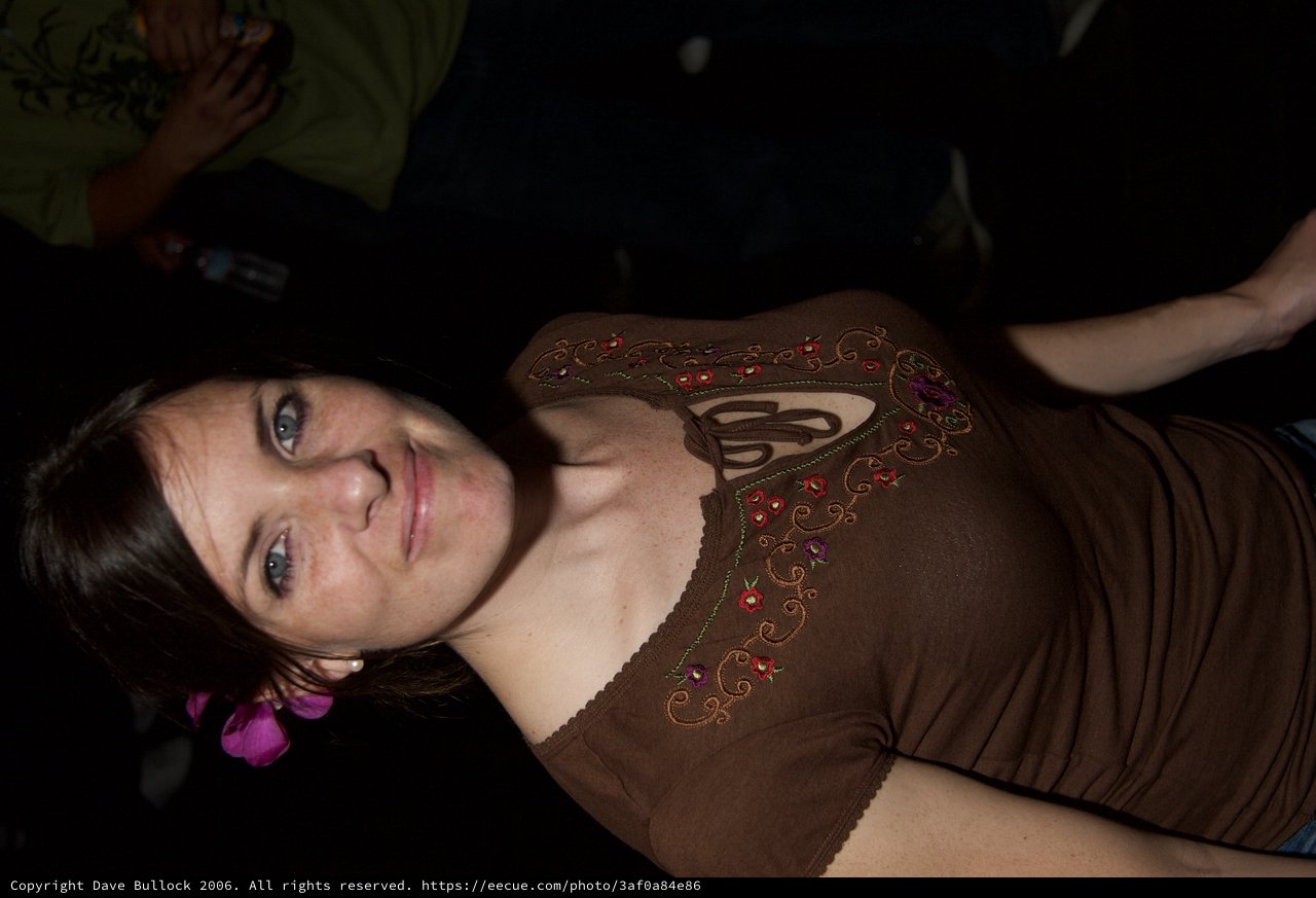 Woman with Pink Flower Smiling at Night Event