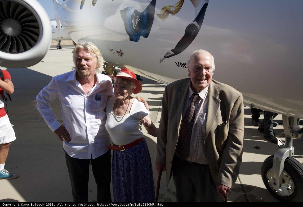Richard Branson and a Woman Standing Next to an Airplane