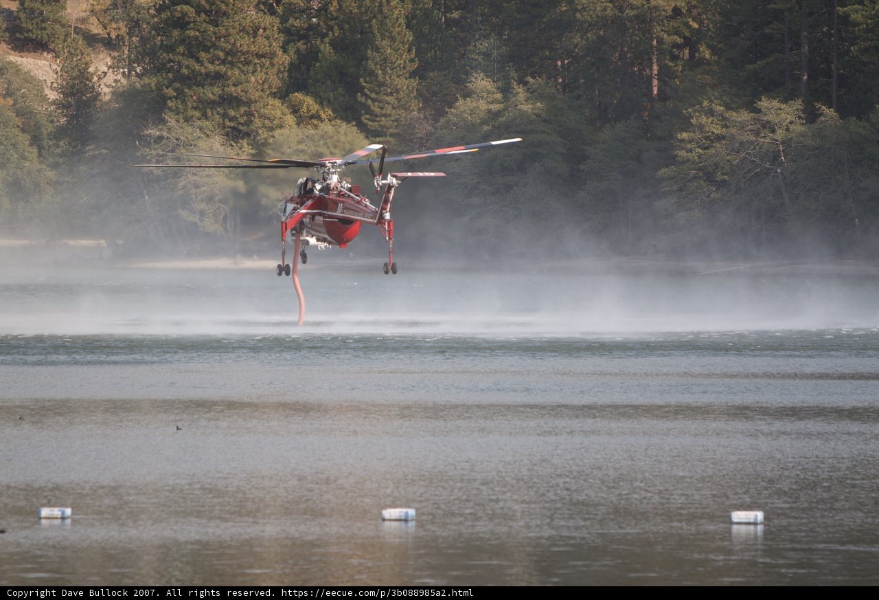 Helicopter aids in firefighting over a lake