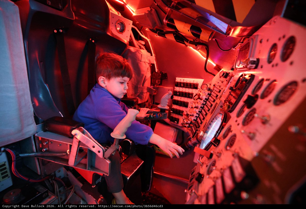 Young Explorer in Submarine Control Room Under Red Light