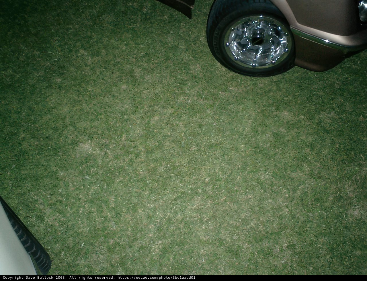 Parked Car with Alloy Wheel on Grass
