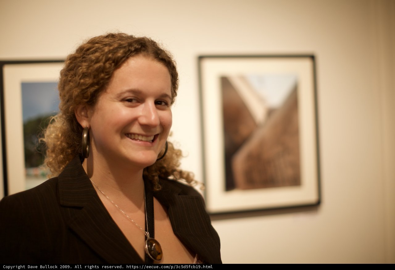 Curly-haired Woman Smiling in Front of Wall