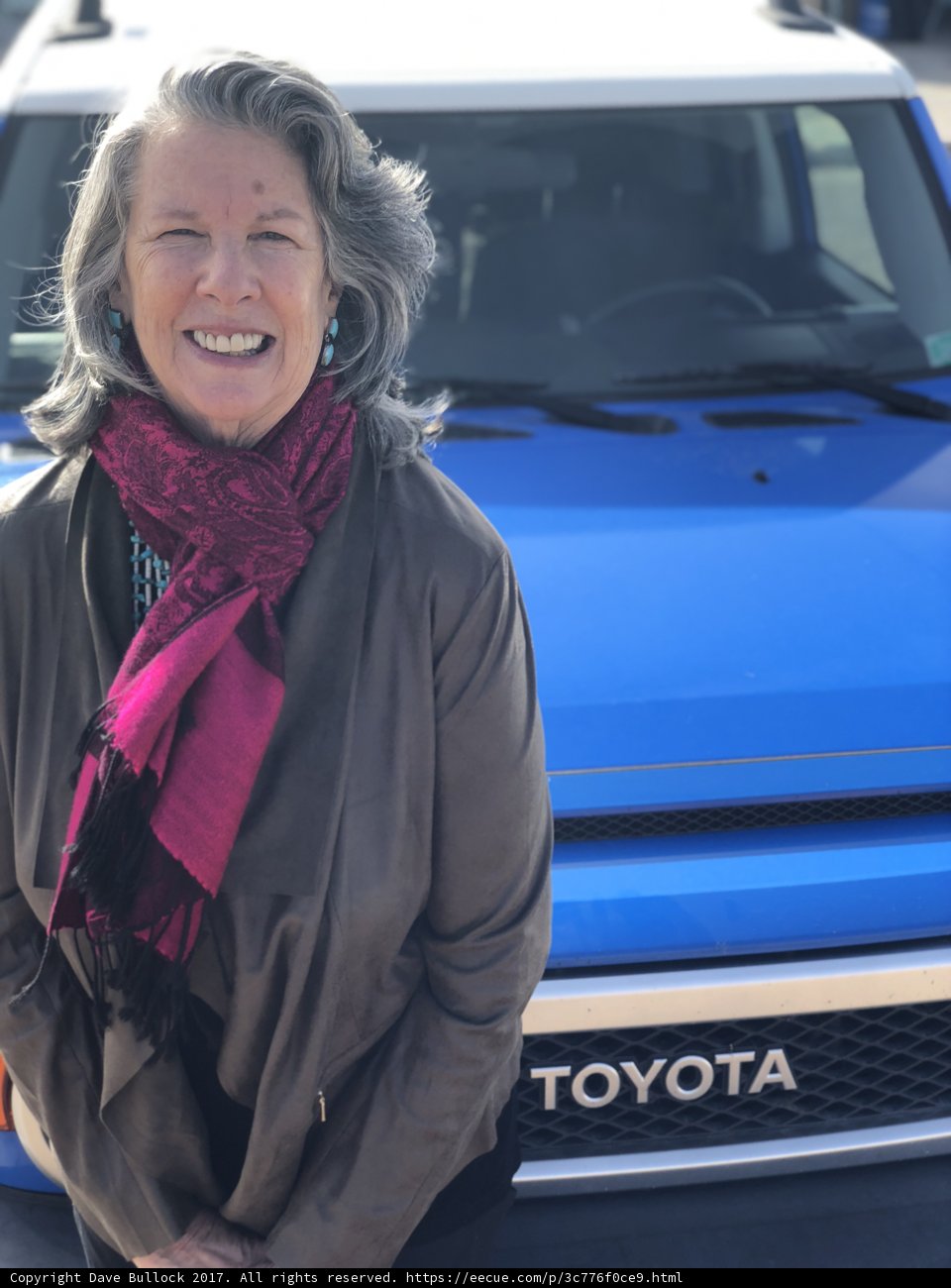 Woman Poses Next to Her Blue Toyota Truck