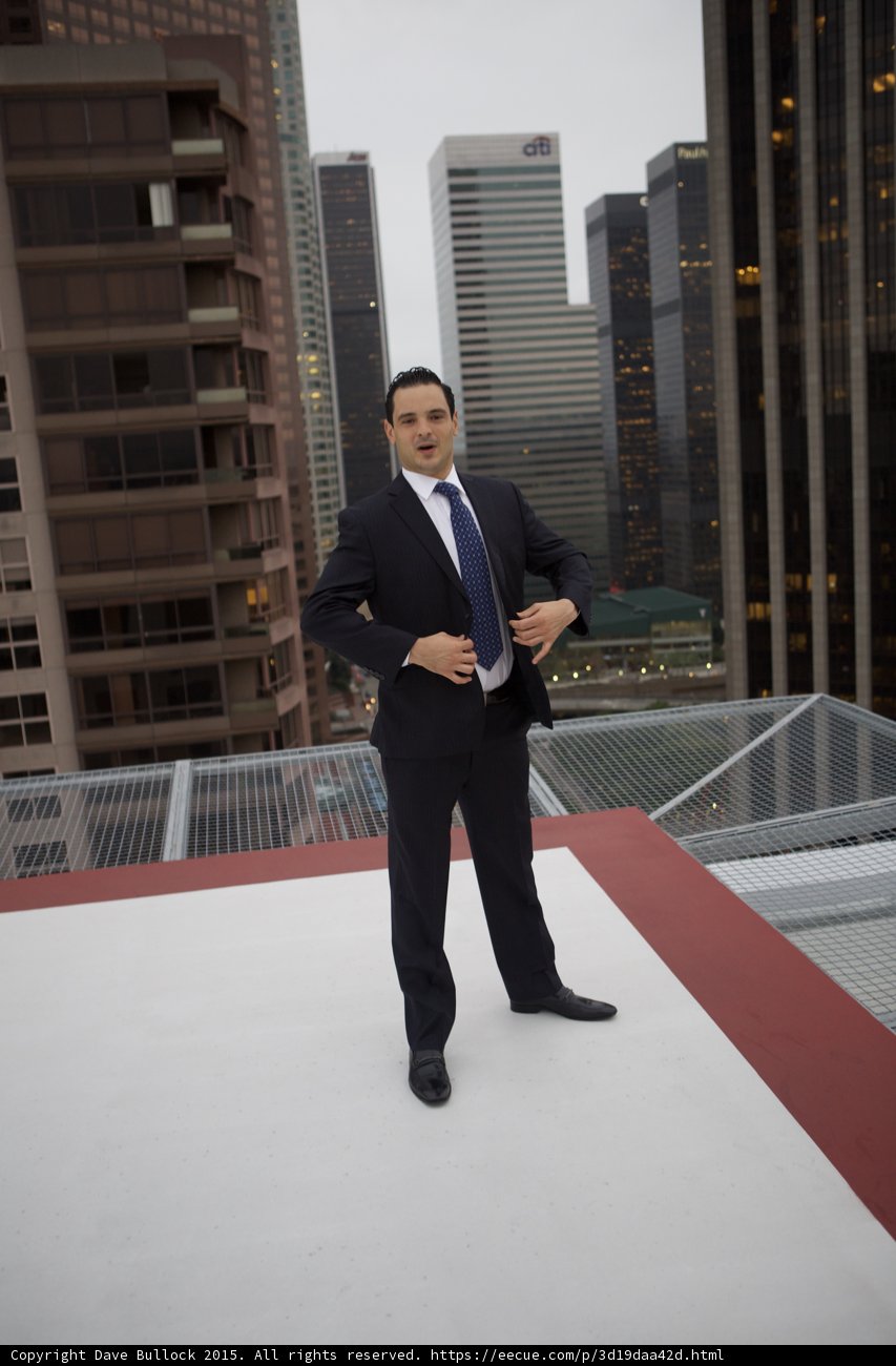 Man in Suit Stands Tall on Skyscraper Roof