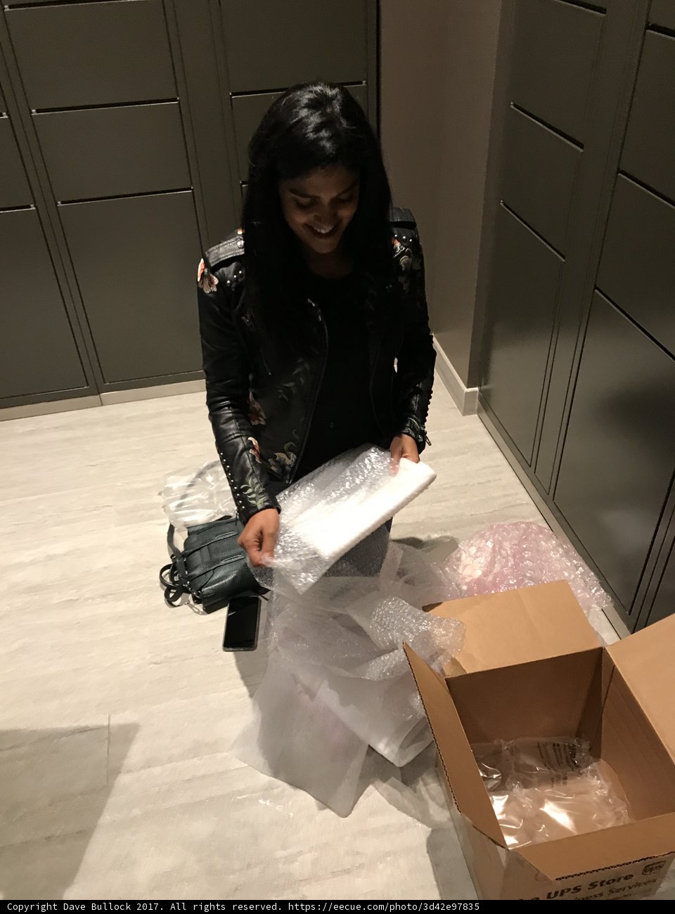 Woman with Coat and Bag in Front of Box