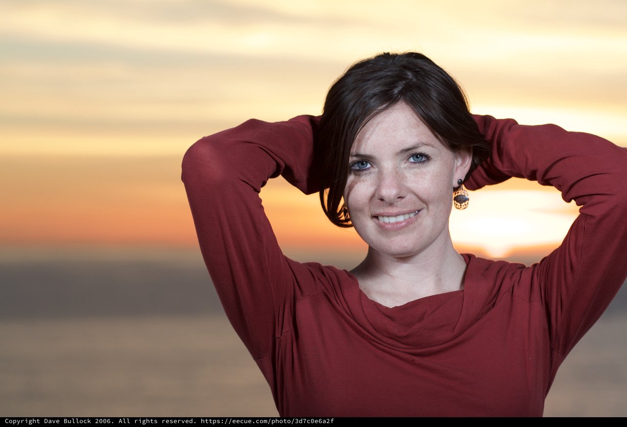 Radiant Woman Smiling at Sunset by the Sea