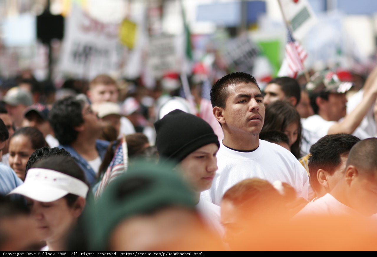 Man in Black Hat Stands Out in Crowded Streets