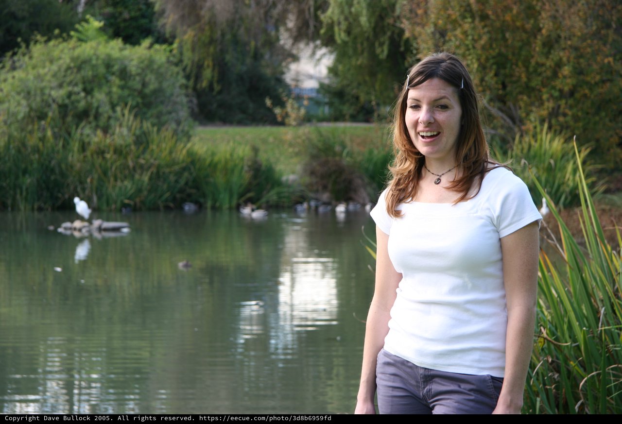 Woman Laughing by a Tranquil Park Pond