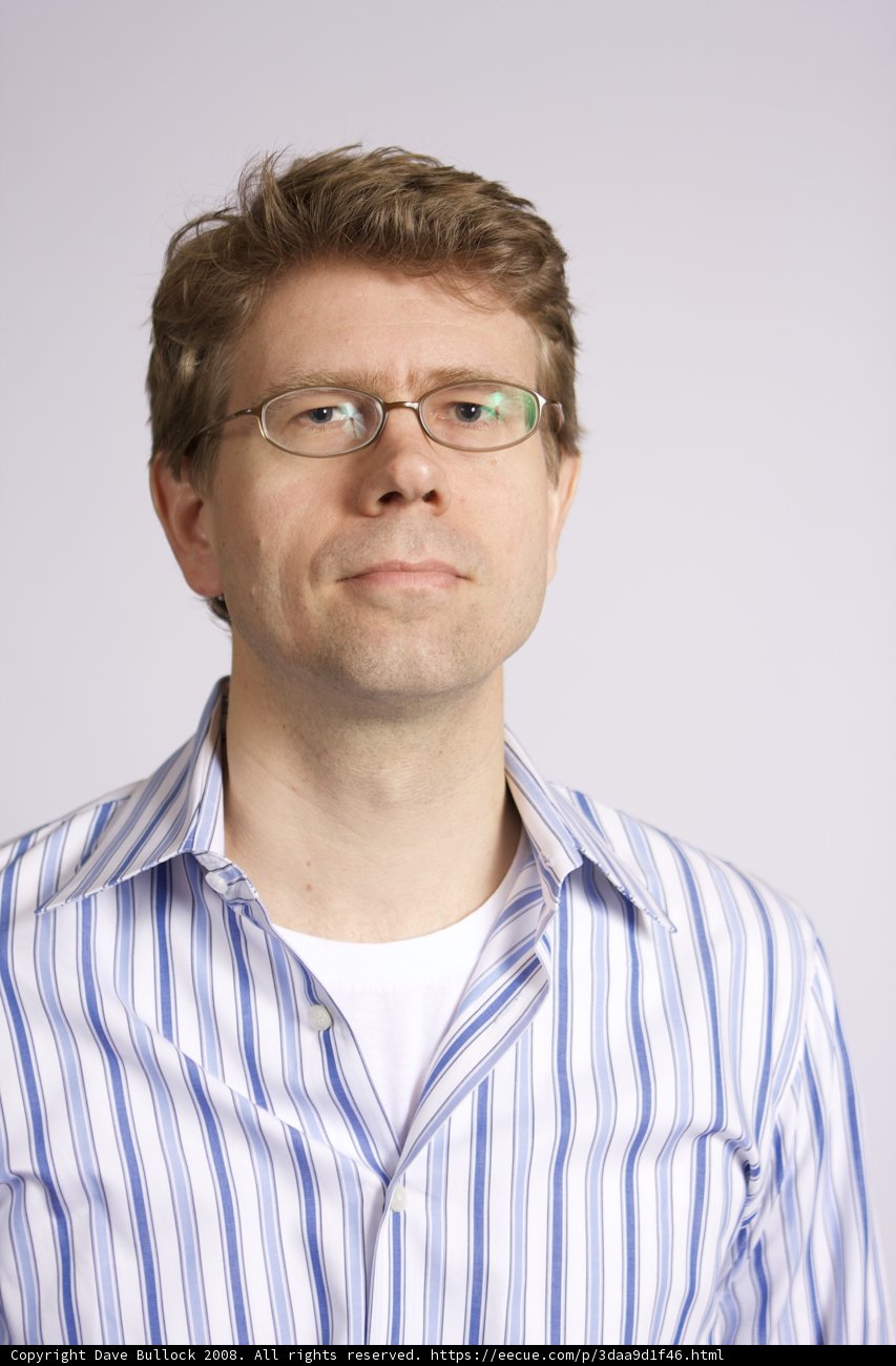 Smiling man in striped shirt and glasses