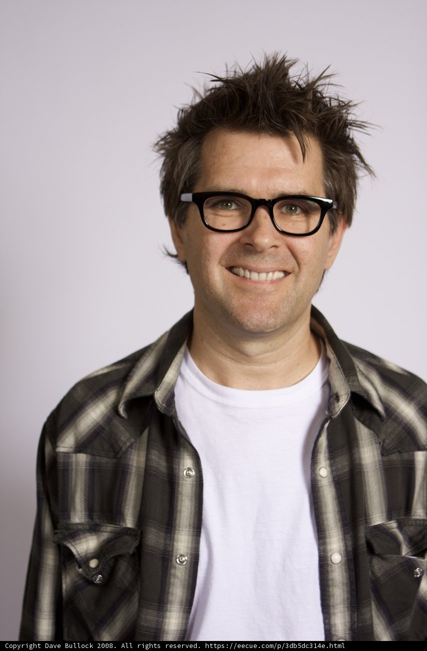 Smiling Man in Plaid Shirt and Glasses