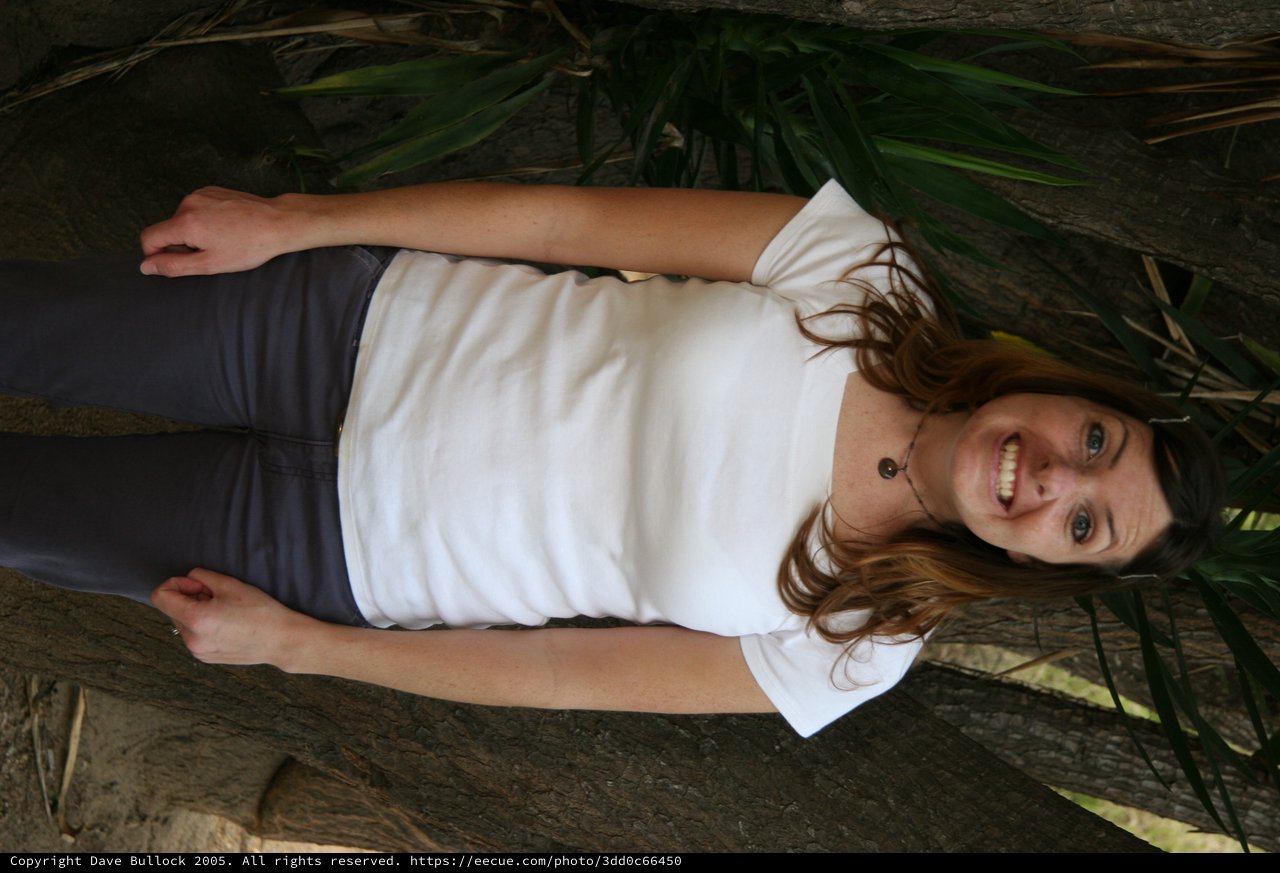 Smiling Woman Poses Outdoors Among Tropical Trees