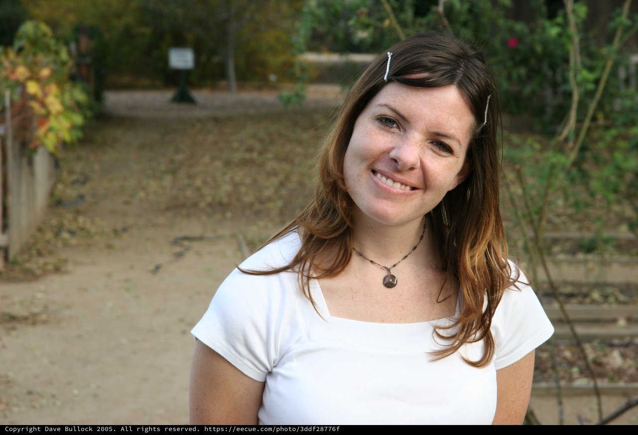 Smiling Woman in White Tee at Outdoor Park