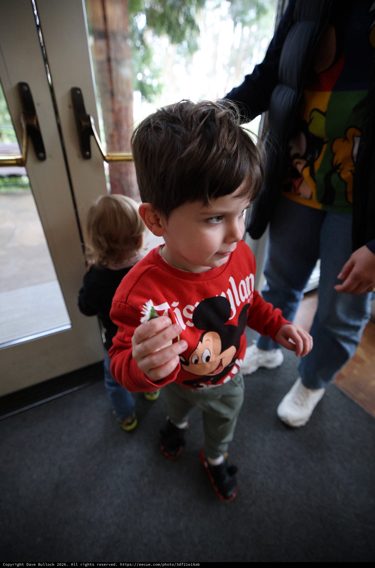 Young Boy with Mickey Mouse Toy at Indoor Gathering
