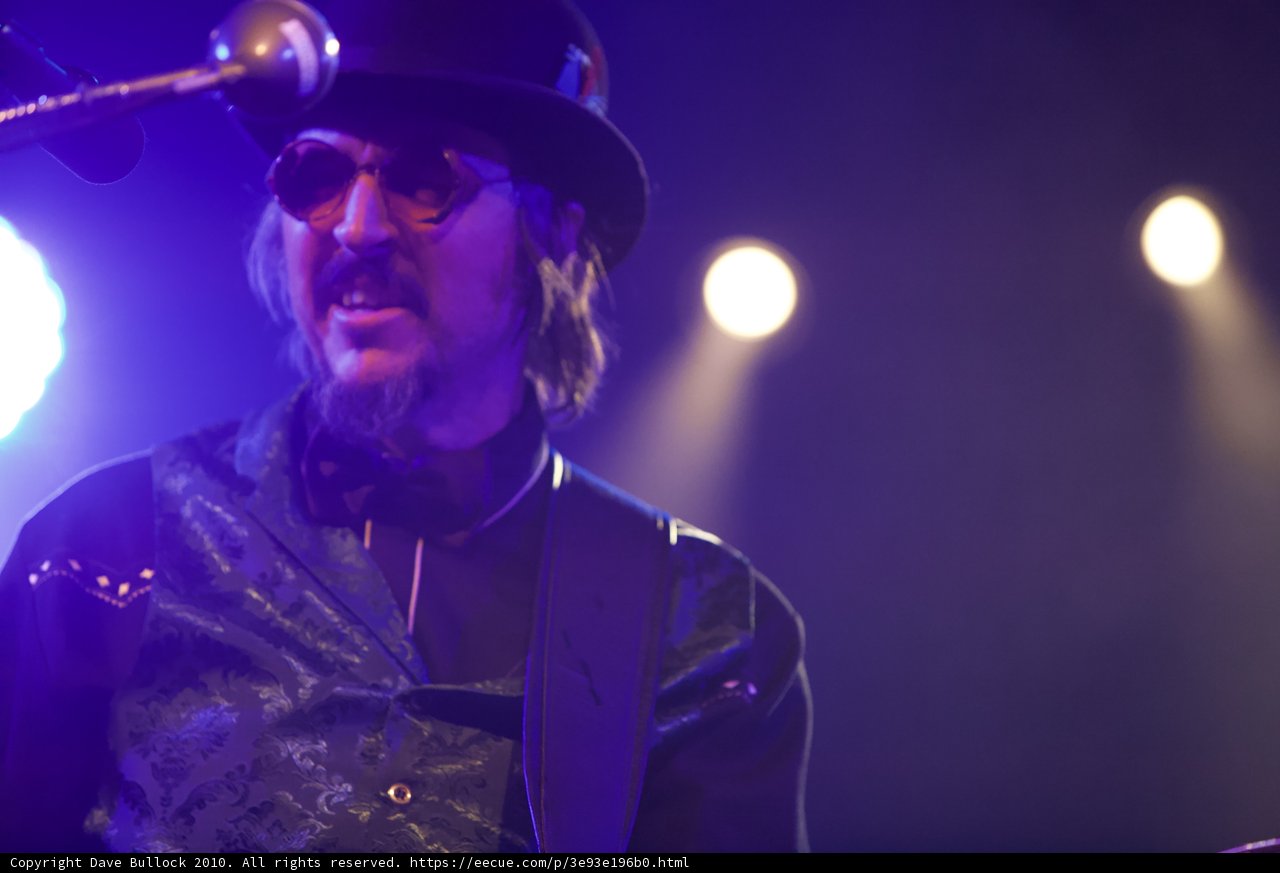 Les Claypool in Top Hat and Bow Tie Rocking the Guitar
