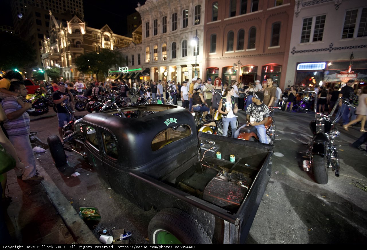 Nighttime Crowd Gathers around Vintage Truck in Metropolis