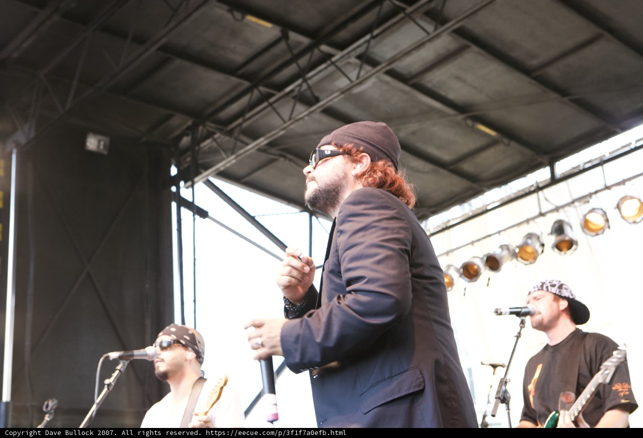 Entertainer on Stage with Two Microphones and Three Hats