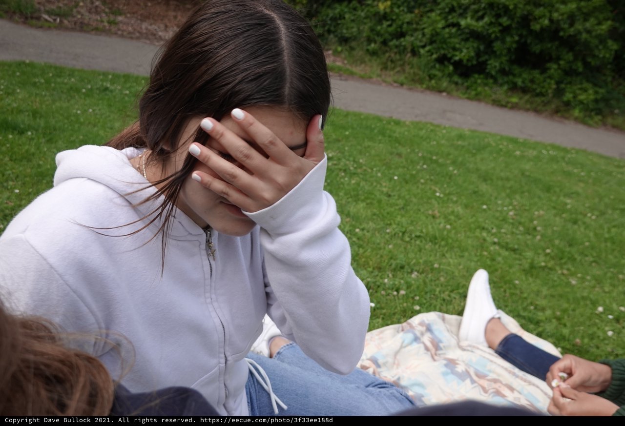 Young Woman Covering Face with Hand Outdoors