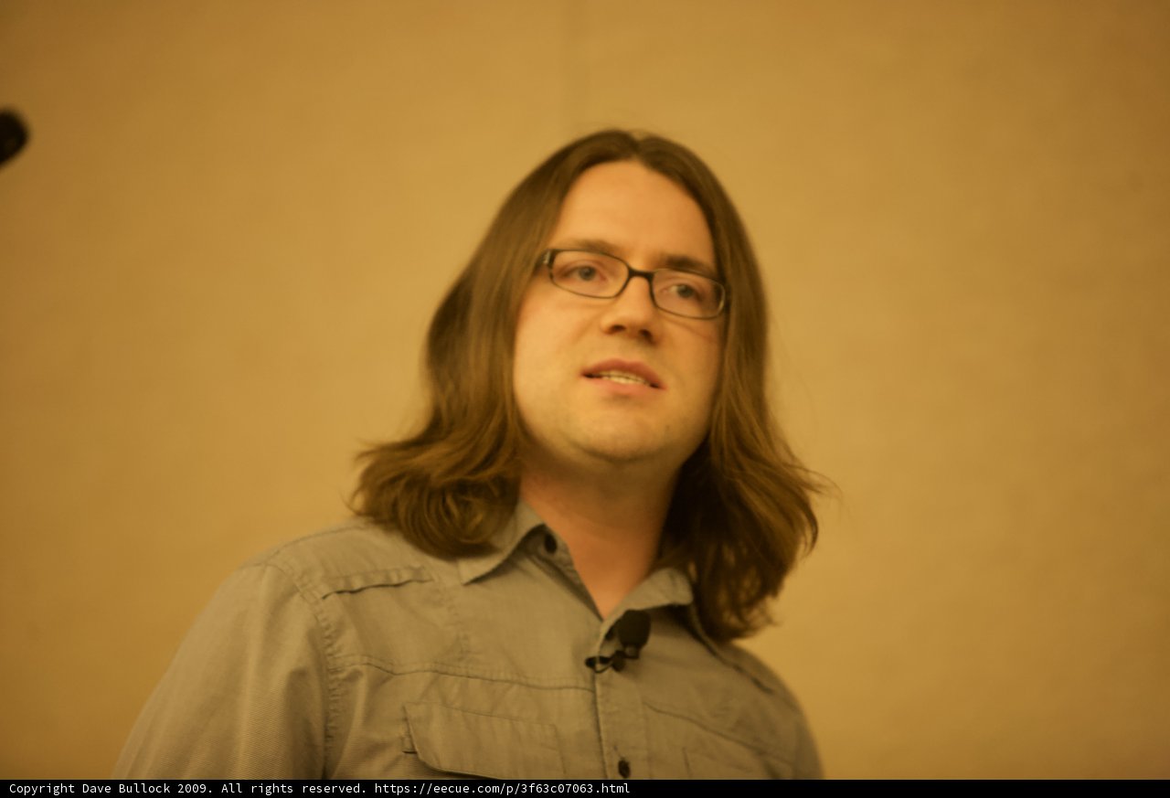 Man with Long Hair and Glasses on Stage